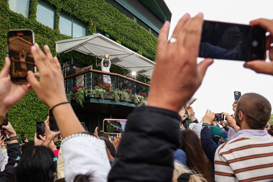 LONDON, ENGLAND - JULY 16: Carlos Alcaraz of Spain lifts the Men's Singles Trophy on Centre Court Balcony as he celebrates with fans following his victory in the Men's Singles Final against Novak Djokovic of Serbia on day fourteen of The Championships Wimbledon 2023 at All England Lawn Tennis and Croquet Club on July 16, 2023 in London, England. (Photo by Patrick Smith/Getty Images)