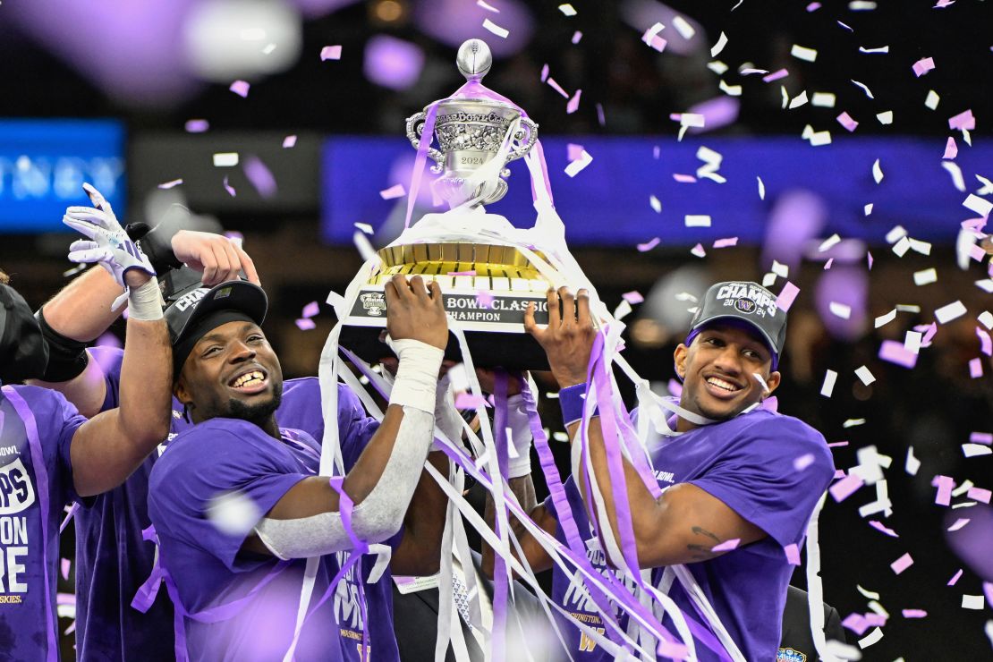 Washington Huskies defensive end Bralen Trice (8) and Washington Huskies quarterback Michael Penix Jr. (9) raise the trophy for winning the Semifinal All State Sugar Bowl football game between the Texas Longhorns and Washington Huskies at the Caesars Superdome on January 1, 2024 in New Orleans Louisiana.