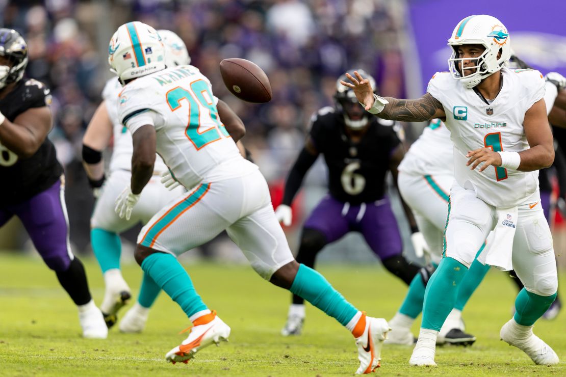 Tua Tagovailoa #1 of the Miami Dolphins shovel passes to De'Von Achane #28 of the Miami Dolphins during an NFL football game between the Baltimore Ravens and the Miami Dolphins at M&T Bank Stadium on December 31, 2023 in Baltimore, Maryland.