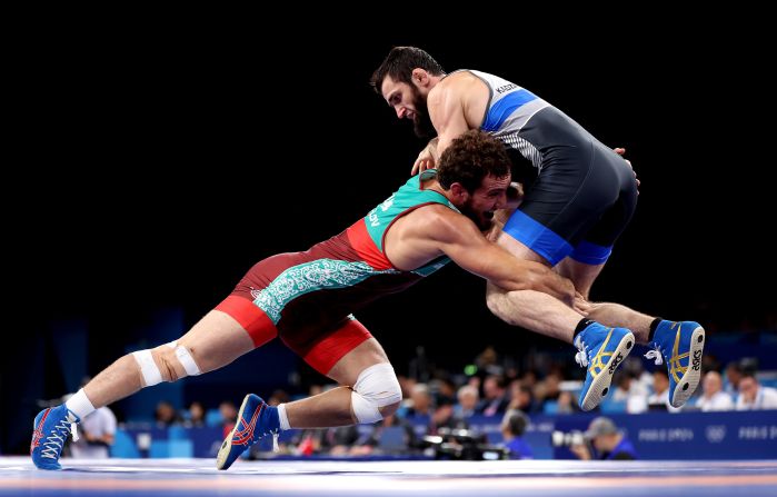 Uzbekistan's Razambek Zhamalov, left, wrestles Mahamedkhabib Kadzimahamedau, a member of the neutral athletes team, on August 9. Amid the <a href=