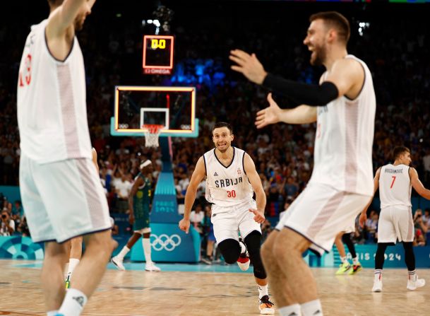 Serbian players celebrate their quarterfinal win over Australia on August 6. <a href=