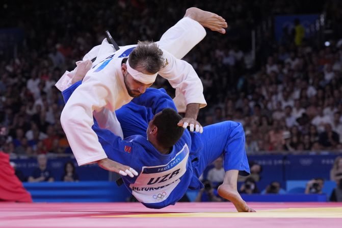 Azerbaijan's Zelym Kotsoiev, top, and Uzbekistan's Muzaffarbek Turoboyev compete in a judo semifinal on August 1. <a href=