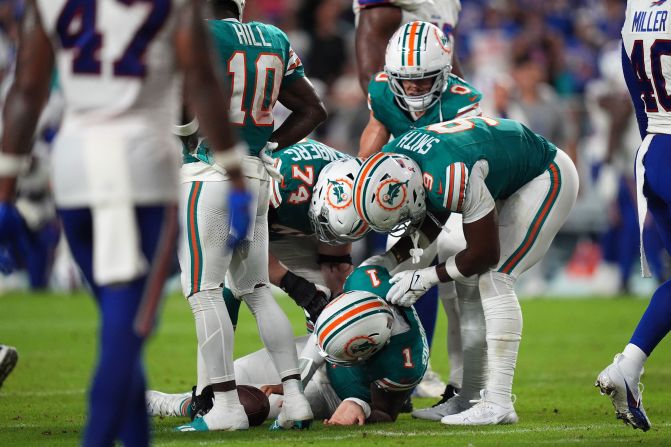 Miami Dolphins players attend to quarterback Tua Tagovailoa after <a href=