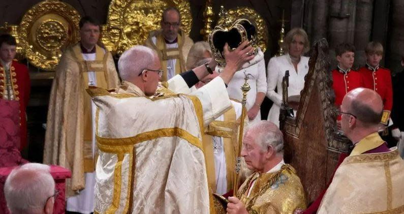 Justin Welby, the former Archbishop of Canterbury, stands in front of King Charles to place the crown on his head, during his coronation ceremony at Westminster Abbey